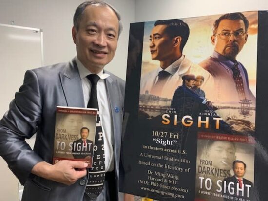 Dr. Ming Wang stands in front of a poster for the film Sight and holds his autobiography, From Darkness to Sight. Dr. Ming Wang says of his first step toward faith, “Although I had been exposed to world literature in my education in China, I knew very little about religion and spirituality. The concept of faith was very foreign to me, but at that moment, a thought emerged deep inside me: if there is indeed a God in the universe, now would be the time for him to appear.”